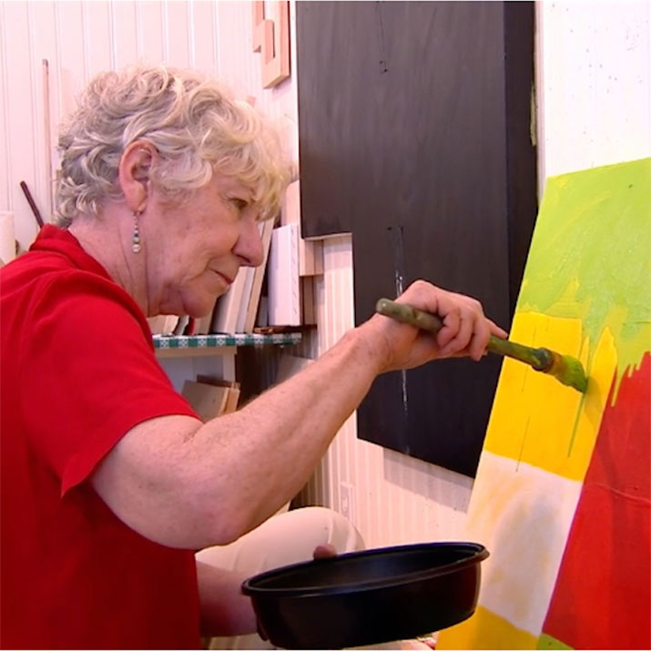 Woman painting a canvas in art studio.
