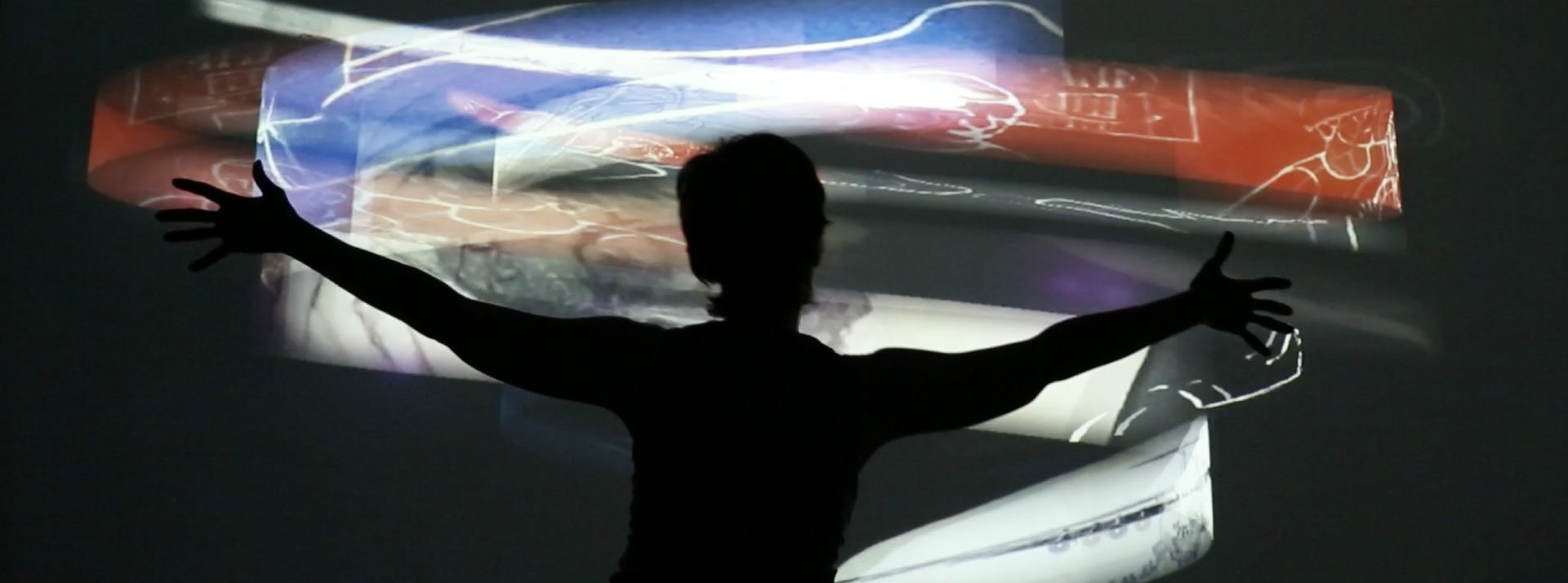 Person in front of digital projection of abstract shapes created by light blurring.
