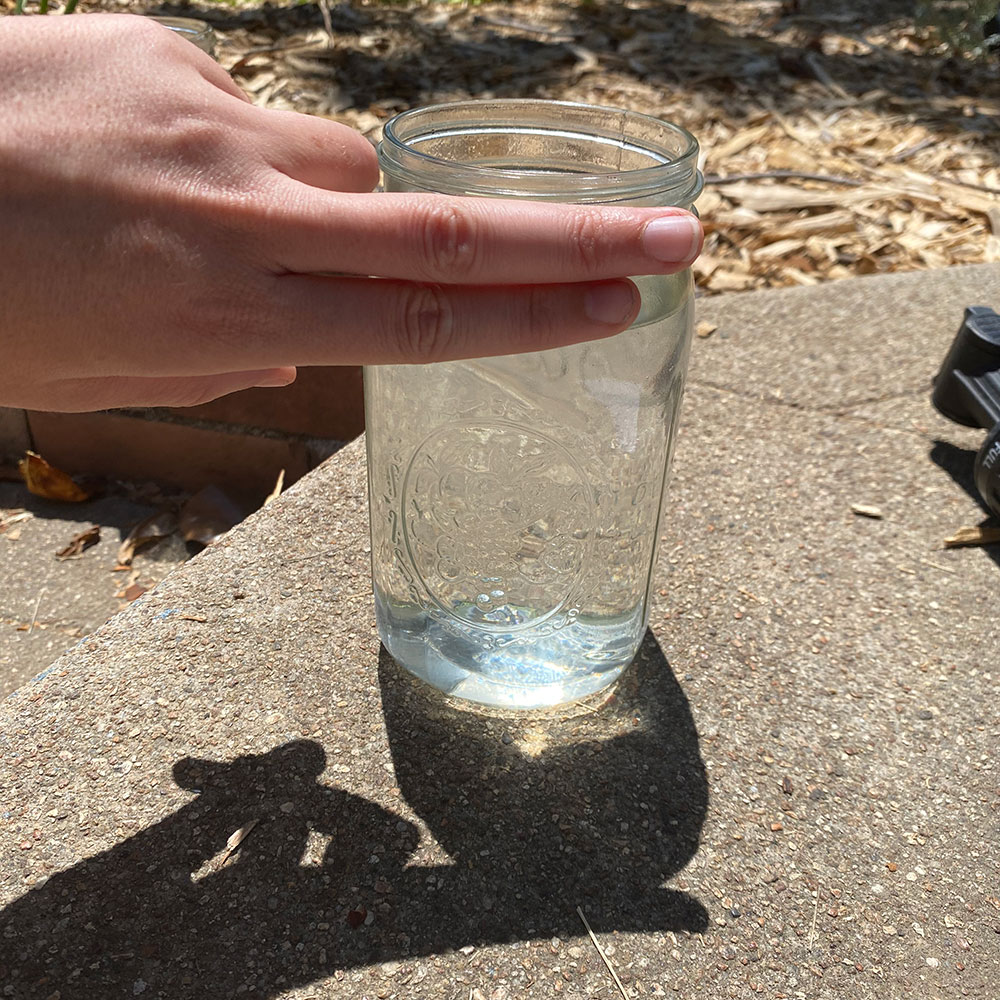 Showing water level from top of the glass using two fingers to measure.