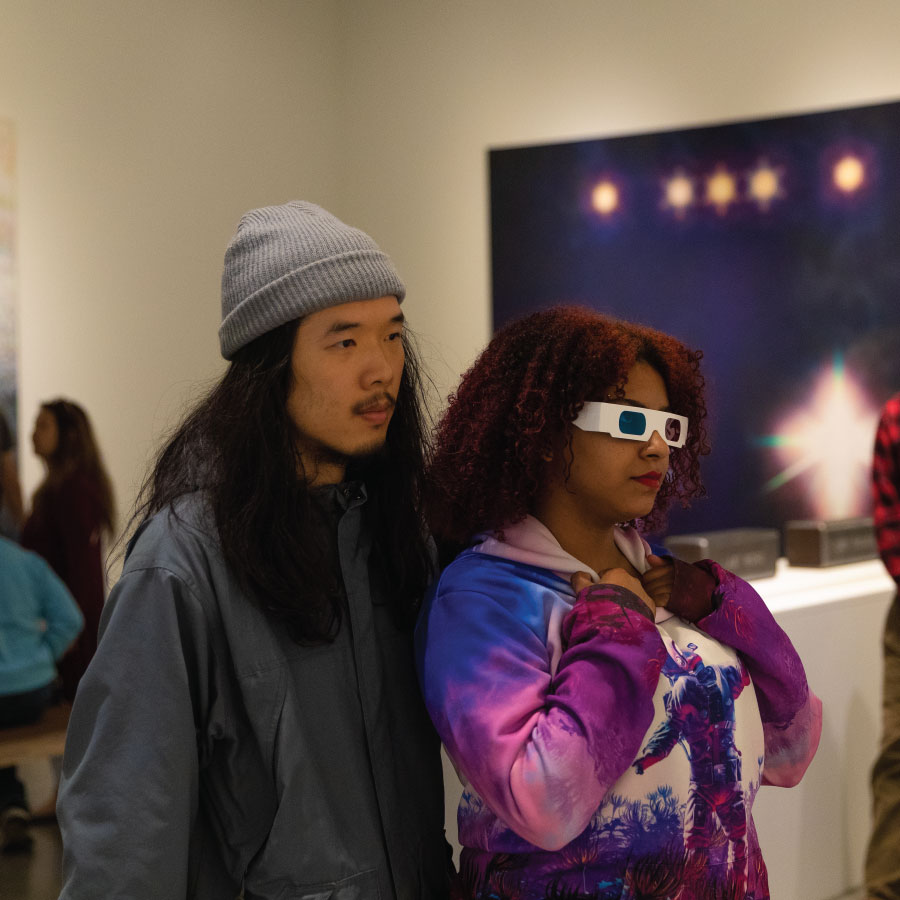 Two people looking at art with 3d glasses.