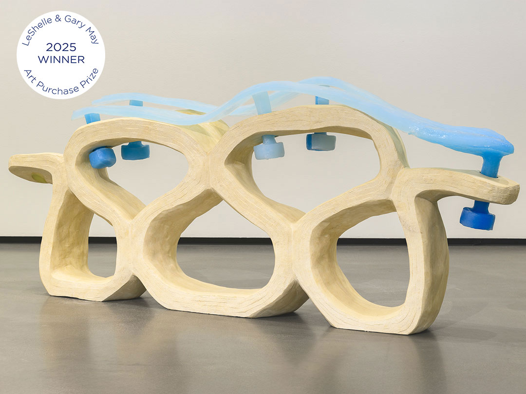 Abstract sculpture with light brown and blue curved shapes.