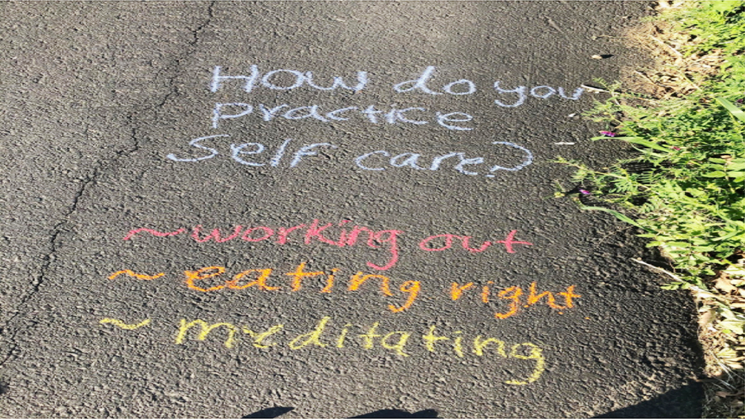 Chalk writing on the ground that asks how one practices self-care.