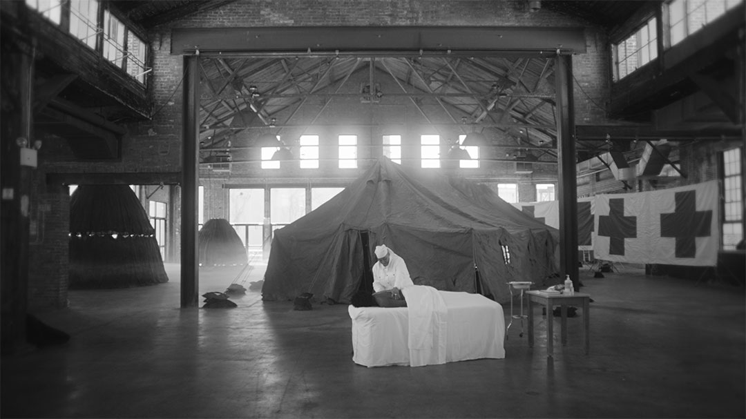 Black and white photo of a nurse in a warehouse.