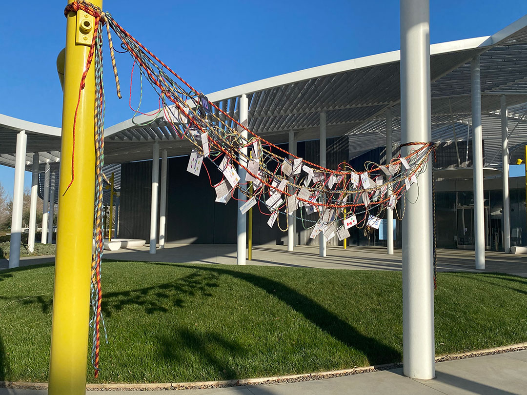 Rope tied between two poles with student schedules hanging off it.