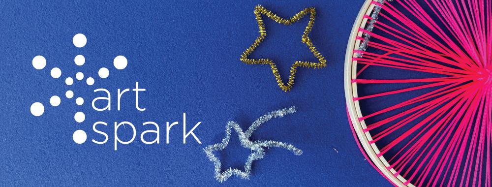 Bright pink string in a wooden hoop with gold and silver pipe cleaner stars on a blue background.