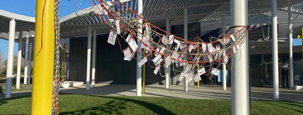 Rope tied between two poles with student schedules hanging off it.