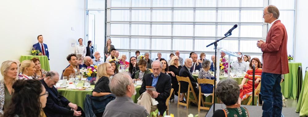 Person speaking at a luncheon at the museum.