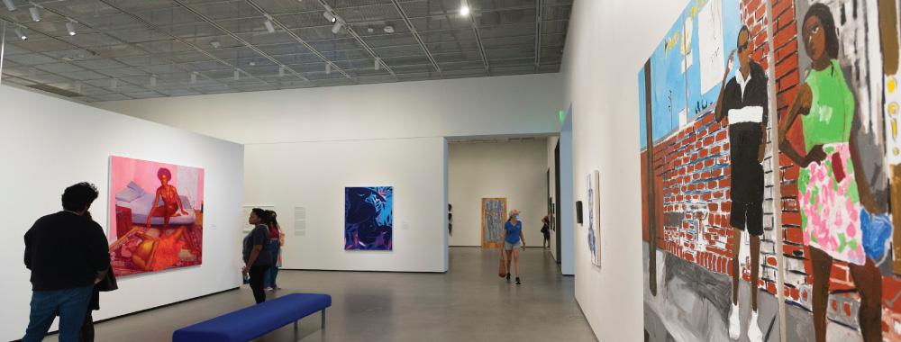 People in the galleries looking at paintings on the walls for the exhibition 'Young, Gifted and Black'.