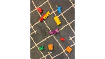 Colorful children's blocks on a grey carpet.