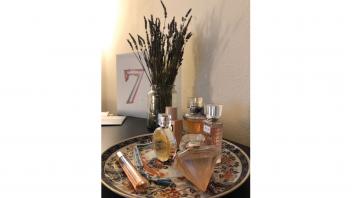 Perfume bottles on a table with lavender flowers.