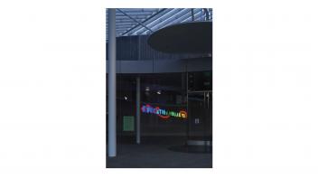 Neon artwork installed at the museum reading 'Education Should Be Free' seen from outside the museum.