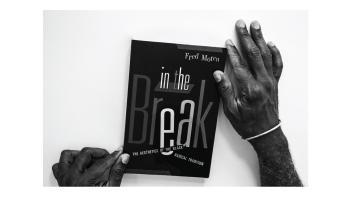 Black and white photo of hands holding a book titled 'In the Break' by Fred Moten.