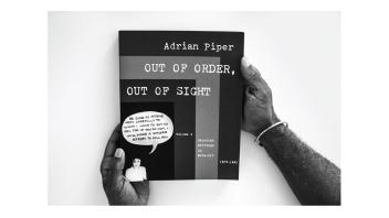Black and white photo of hands holding a book titled 'Out of Order, Out of Sight' by Adrian Piper.