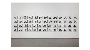 Installation photo of Kemp's Possible Bibliography art featuring 52 black and white photos.