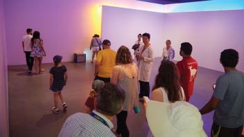 Student guiding visitors at the Nauman Corridor installation.