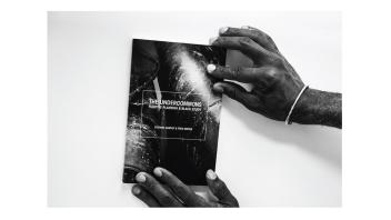 Black and white photo of hands holding a book titled 'The Undercommons' by Stefano Harney and Fred Moten.