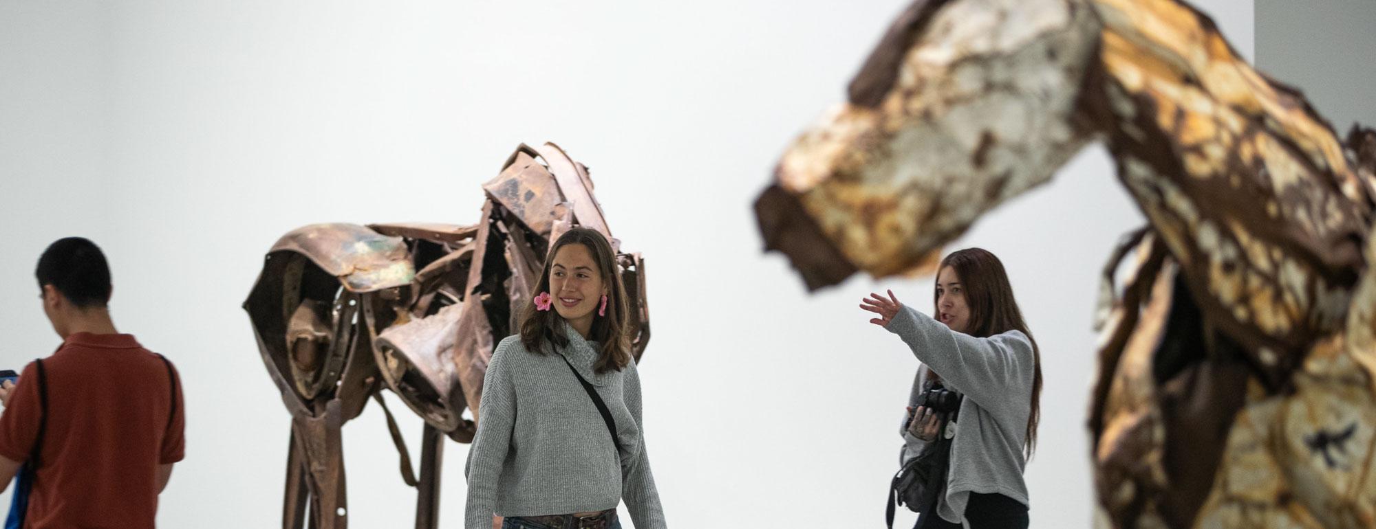 Students in the galleries looking at the scrap metal horse sculptures by Deborah Butterfield.