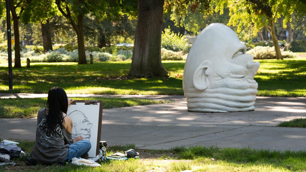 Student drawing Arneson's egghead sculpture 'Eye on Mrak'. 