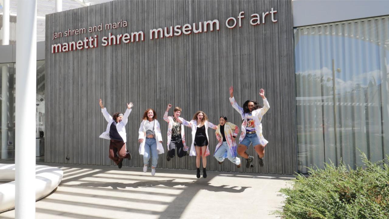 Students jumping in front of the museum.