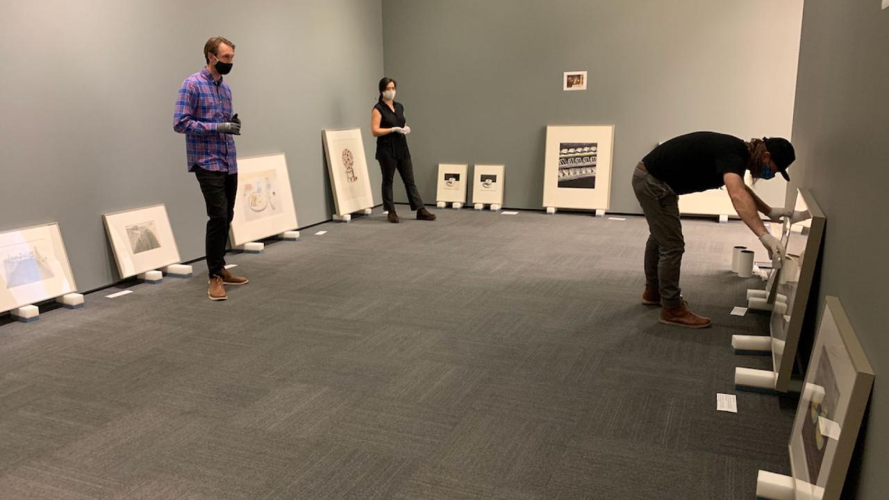 Staff installing artwork in the gallery