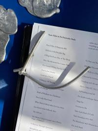 List with various abstract, silver objects around and on top of it.