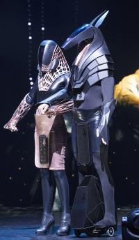 Two people in futuristic looking clothing and masks that take inspiration from Egyptian deities.