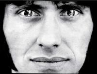 Front view portrait of a man wearing mirrored contact lenses.