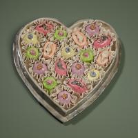 Ceramic sculpture of a heart shaped candy box with pastel colored candies inside.