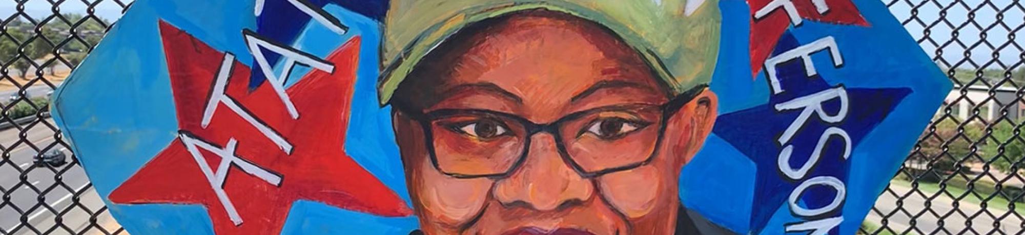 Painting of Atatiana Jefferson on cardboard and attached to a fence on an overpass.