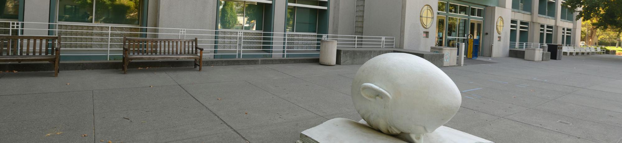 'Bookhead', one of Arneson's Egghead sculptures in front of the library. The egg is laying facedown in an open book.
