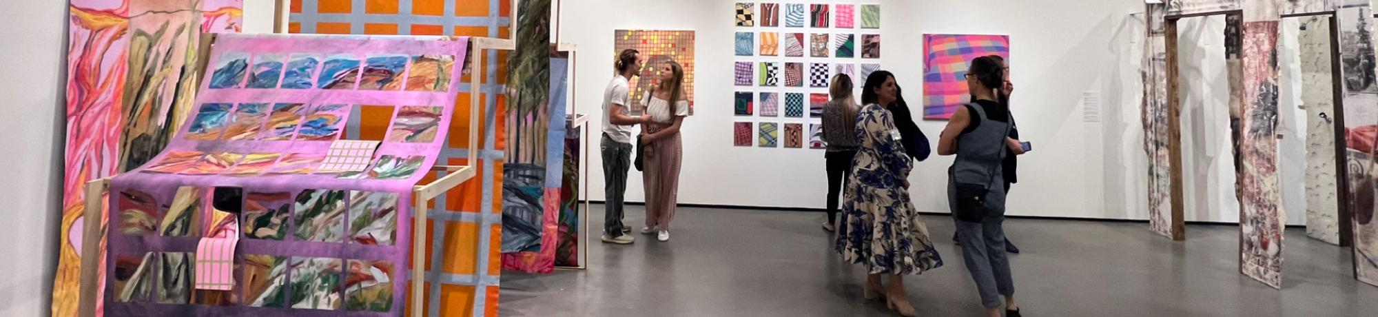 Visitors talking in the galleries during the Arts and Humanities Graduate Exhibition.