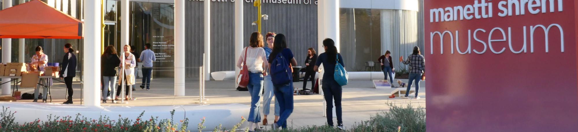Students talking on the plaza in front of the museum.