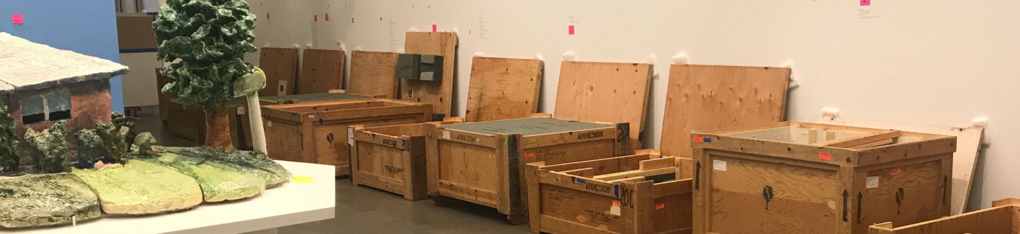 Crates of art lined up in the gallery for installation.