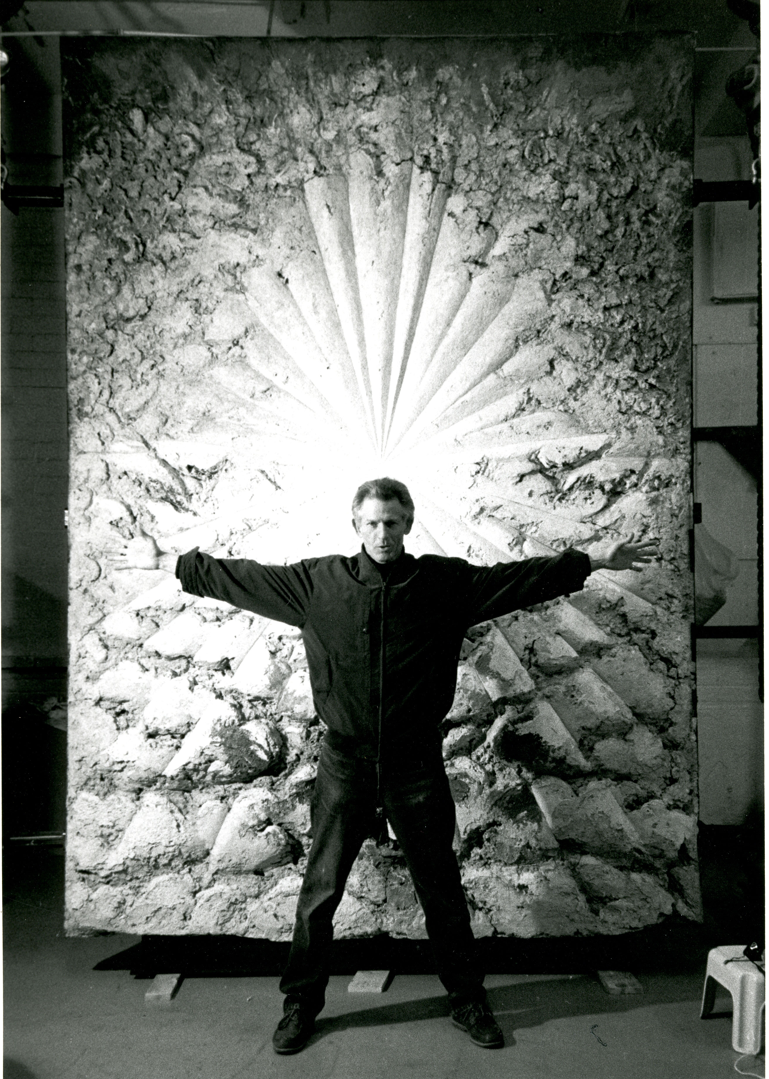Man standing in front of artwork that looks like a burst of light.