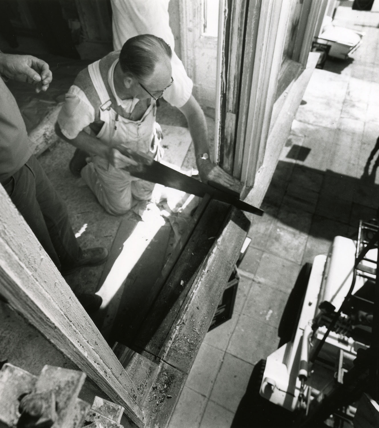 Black and white photo of man with hand saw.