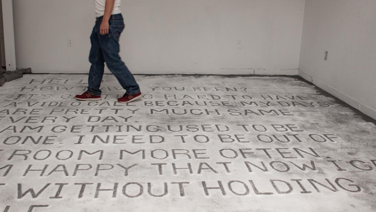 Person walking on large text on a floor.