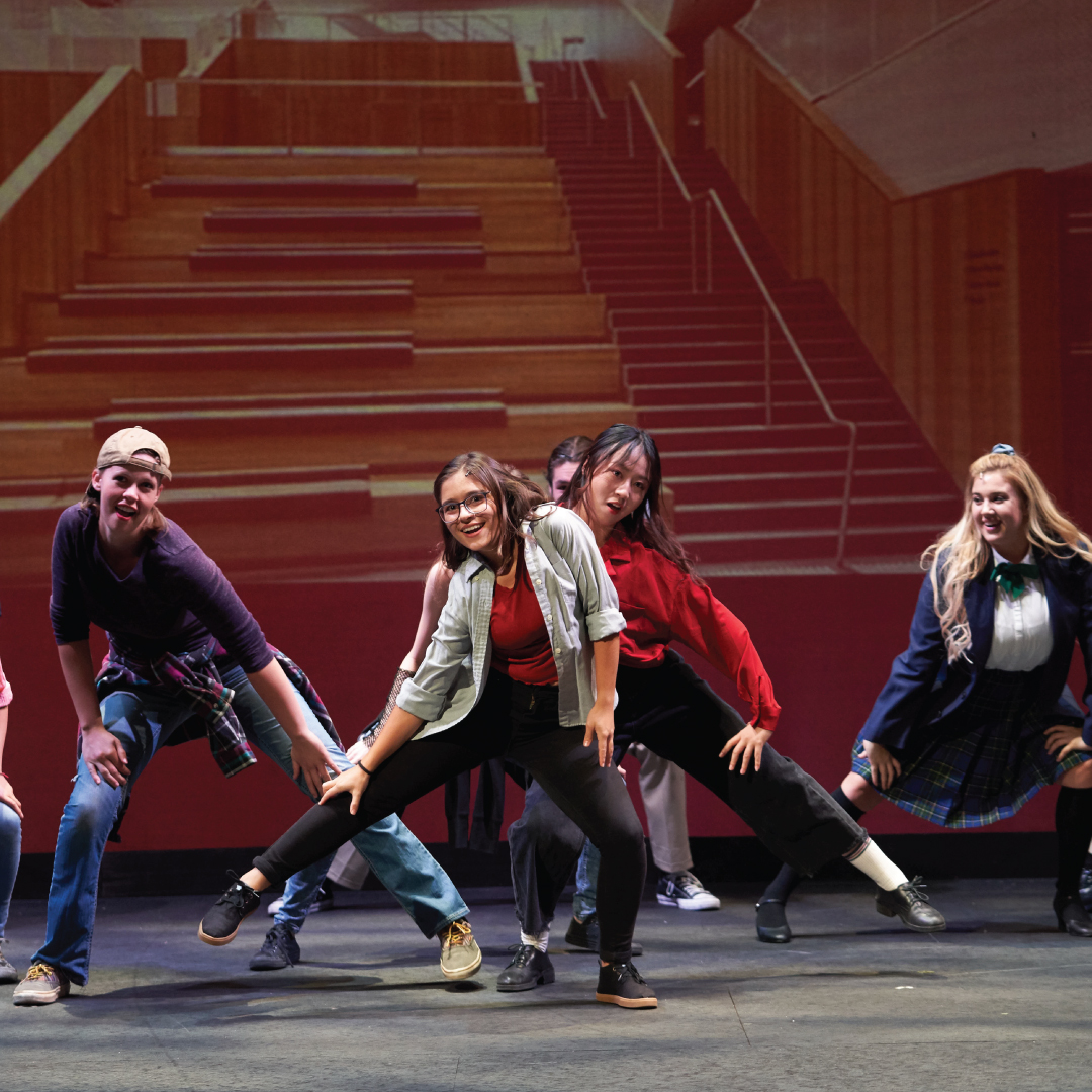 Actors dancing on stage.