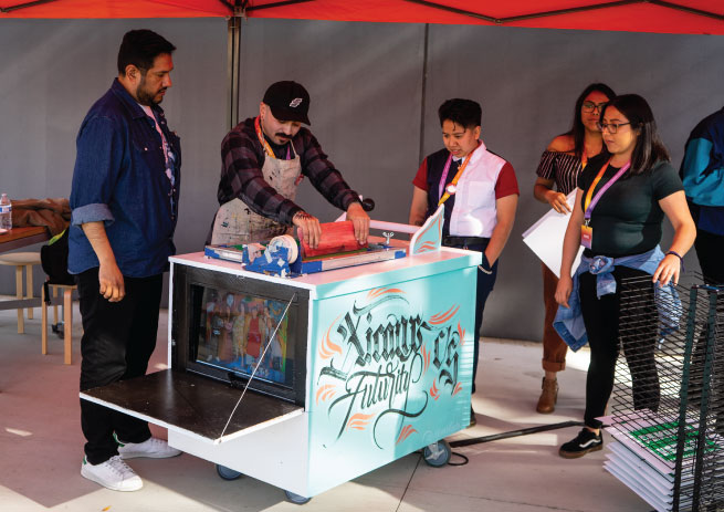 Photo of screen printing with artist Felicia 'Fe' Montes' politricking cart. Photo by Meagan Lucy Photography